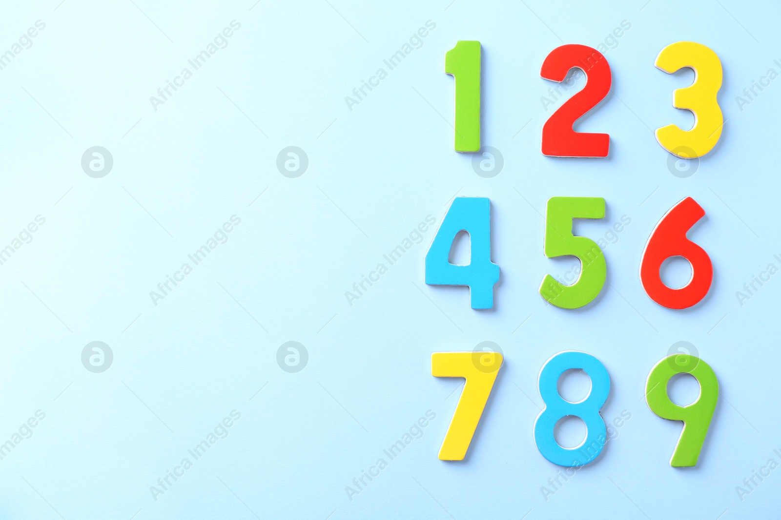 Photo of Colorful numbers on light blue background, flat lay. Space for text