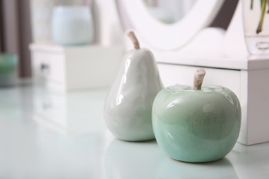 Photo of Beautiful ceramic fruits on white dressing table