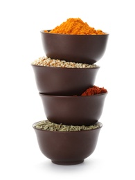 Stack of bowls with different aromatic spices on white background