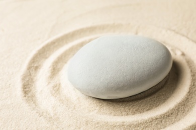 Photo of Zen garden stone on sand with pattern. Meditation and harmony