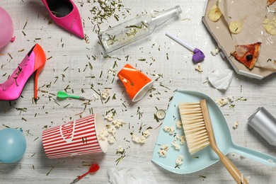 Photo of Brush and dustpan on messy floor after party, flat lay