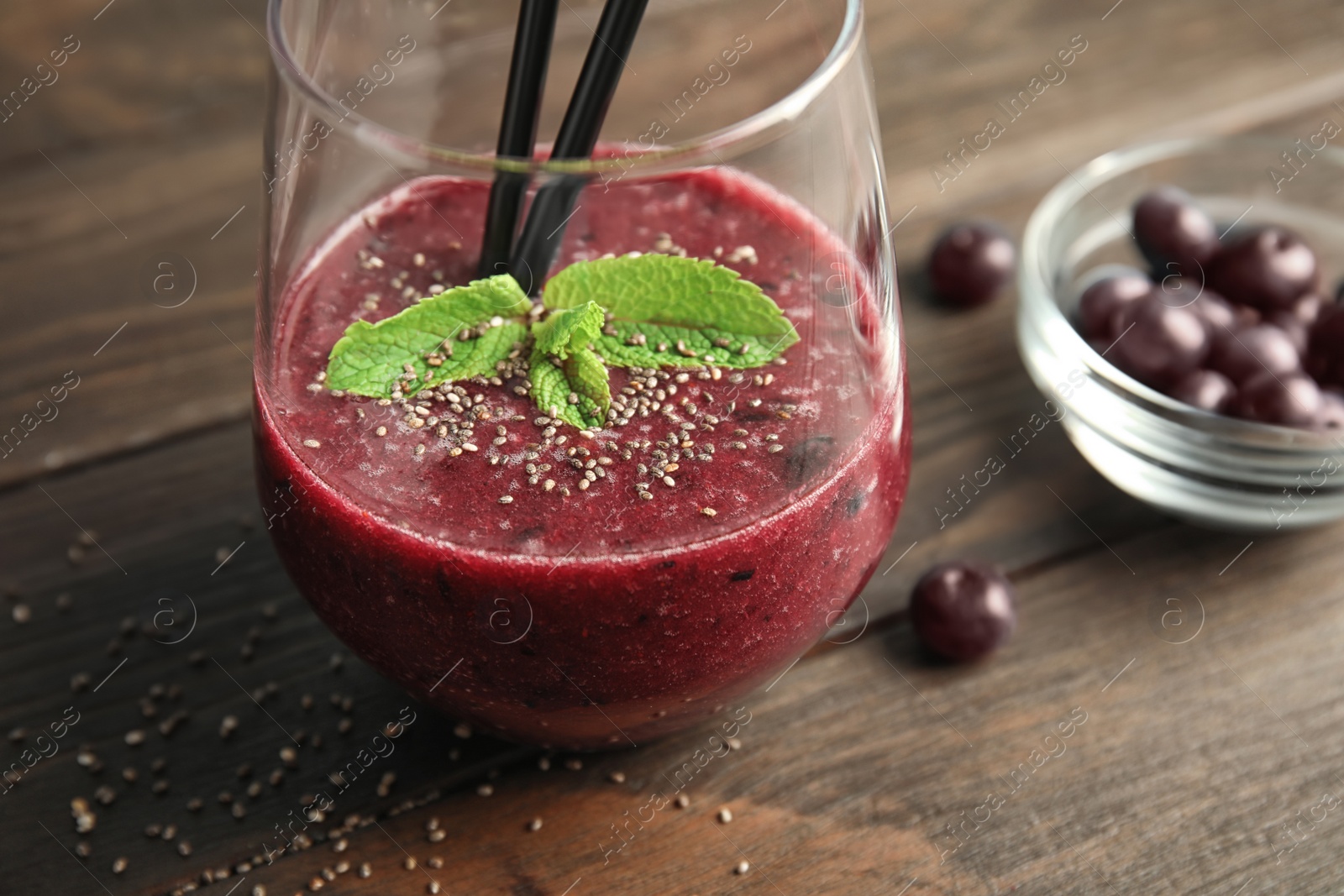 Photo of Glass with delicious acai smoothie on wooden table, closeup