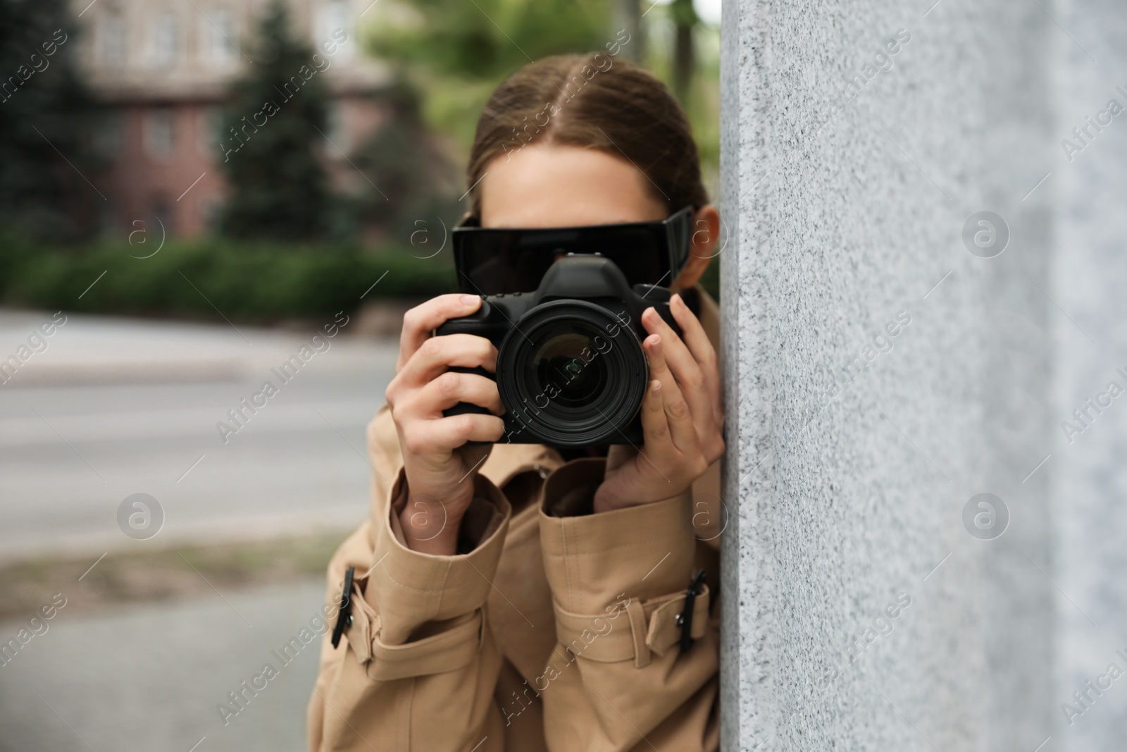 Photo of Private detective with modern camera spying on city street