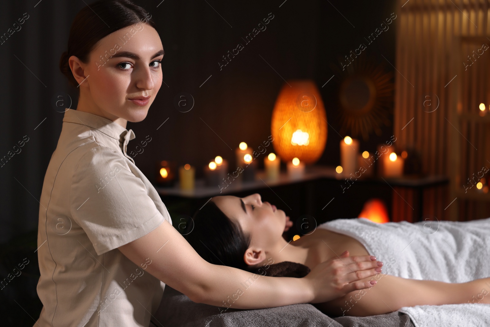 Photo of Spa therapy. Beautiful young woman lying on table during massage in salon