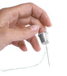 Photo of Woman with thimble and sewing needle on white background, closeup