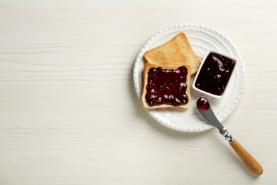 Photo of Delicious toasts with jam served on white wooden table, top view. Space for text