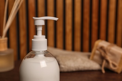 Photo of Bottle with liquid soap on table, closeup. Space for text
