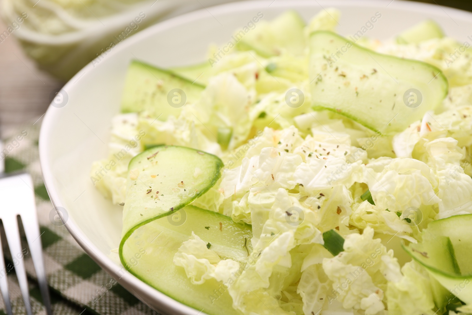 Photo of Tasty salad with Chinese cabbage, cucumber and green onion in bowl on table, closeup