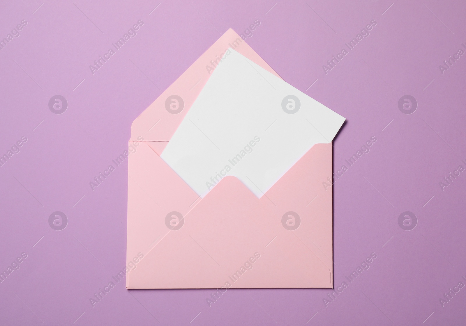 Photo of Letter envelope with card on violet background, top view