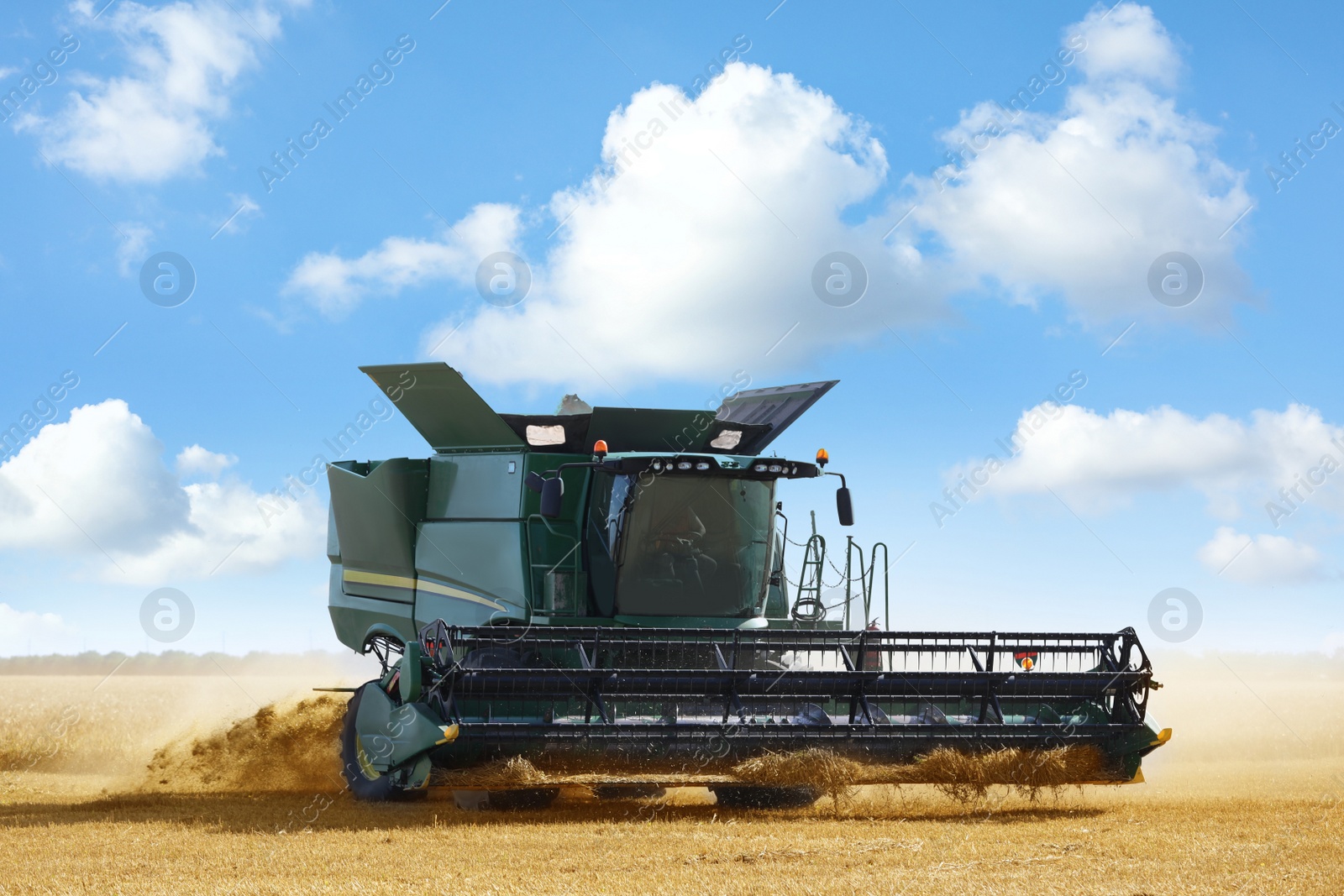 Photo of Modern combine harvester working in agricultural field