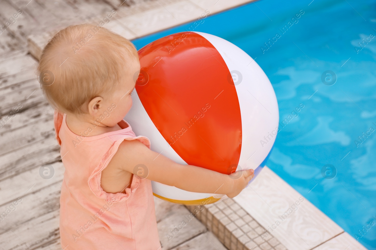 Photo of Little baby playing near outdoor swimming pool. Dangerous situation