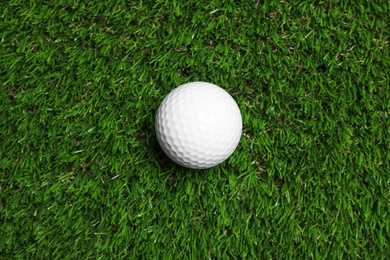 Photo of Golf ball on green artificial grass, top view
