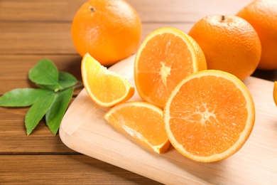 Photo of Delicious ripe oranges on wooden board, closeup