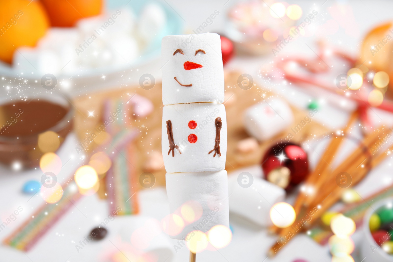 Image of Funny snowman made of marshmallows on blurred background, closeup. Bokeh effect 