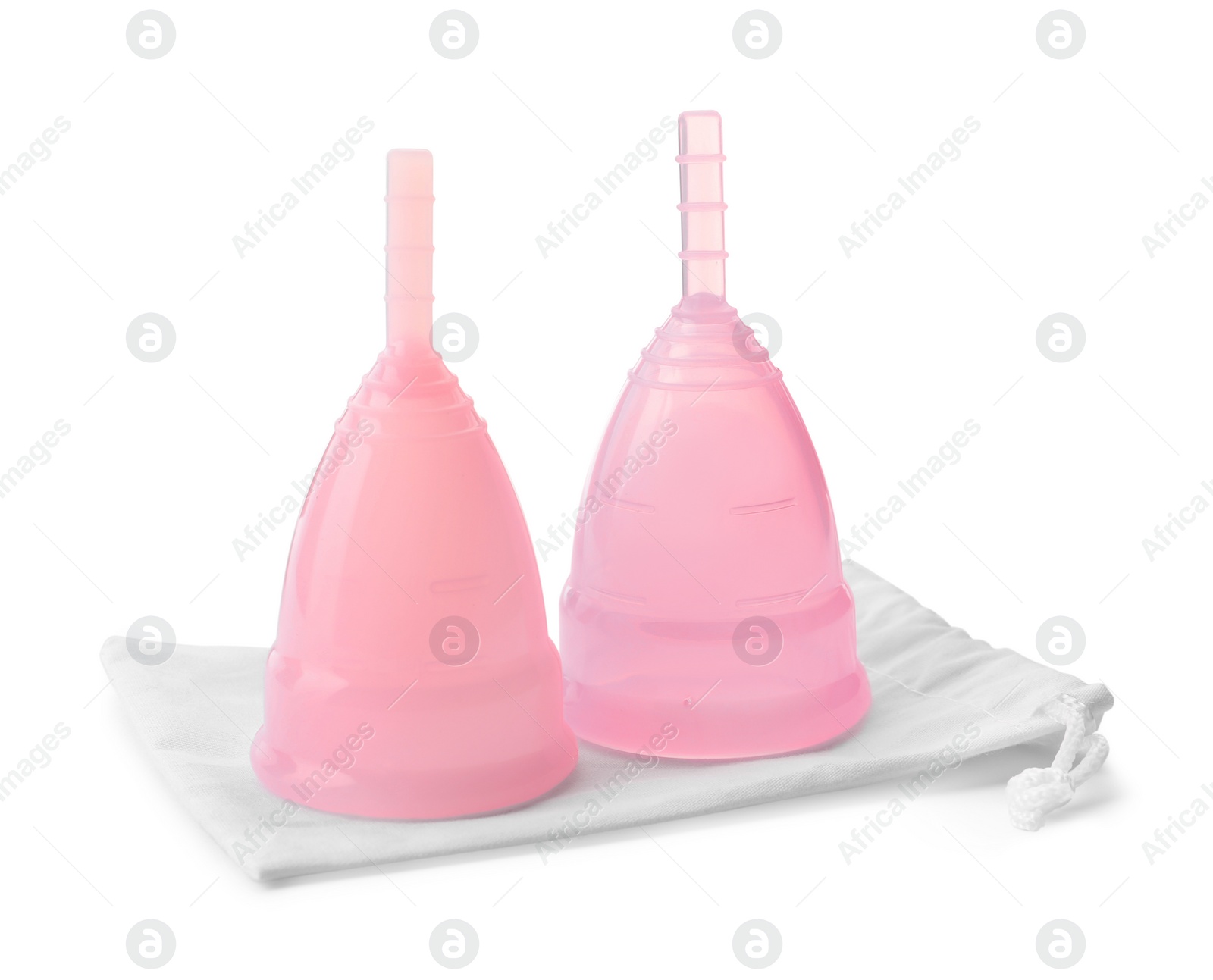 Photo of Pink menstrual cups with cotton bag on white background