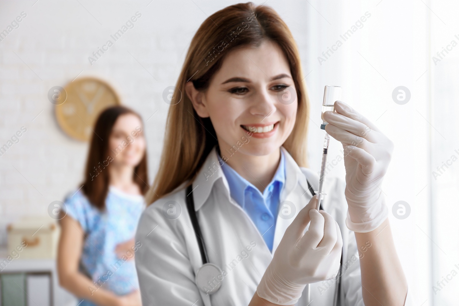 Photo of Doctor holding ampule with vaccine and syringe for patient in clinic