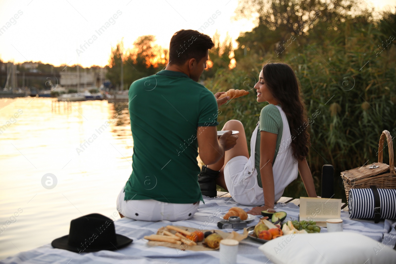 Photo of Happy couple spending time on pier at picnic