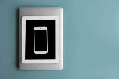 Photo of Devices with blank screens on color background, top view. Mock up for design