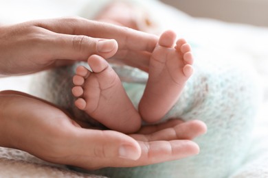 Mother and her newborn baby on white plaid, closeup