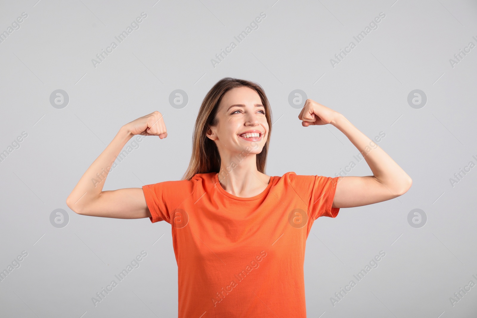 Photo of Strong woman as symbol of girl power on light grey background. 8 March concept