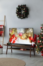 Photo of Stylish living room interior with modern TV and Christmas decor