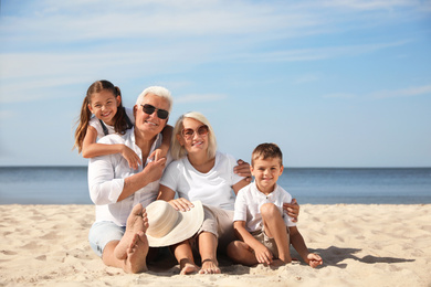 Cute little children with grandparents spending time together on sea beach