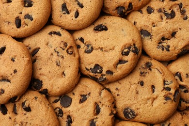 Delicious chocolate chip cookies as background, top view