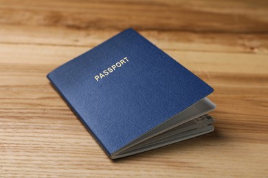 Blank blue passport on wooden table, closeup