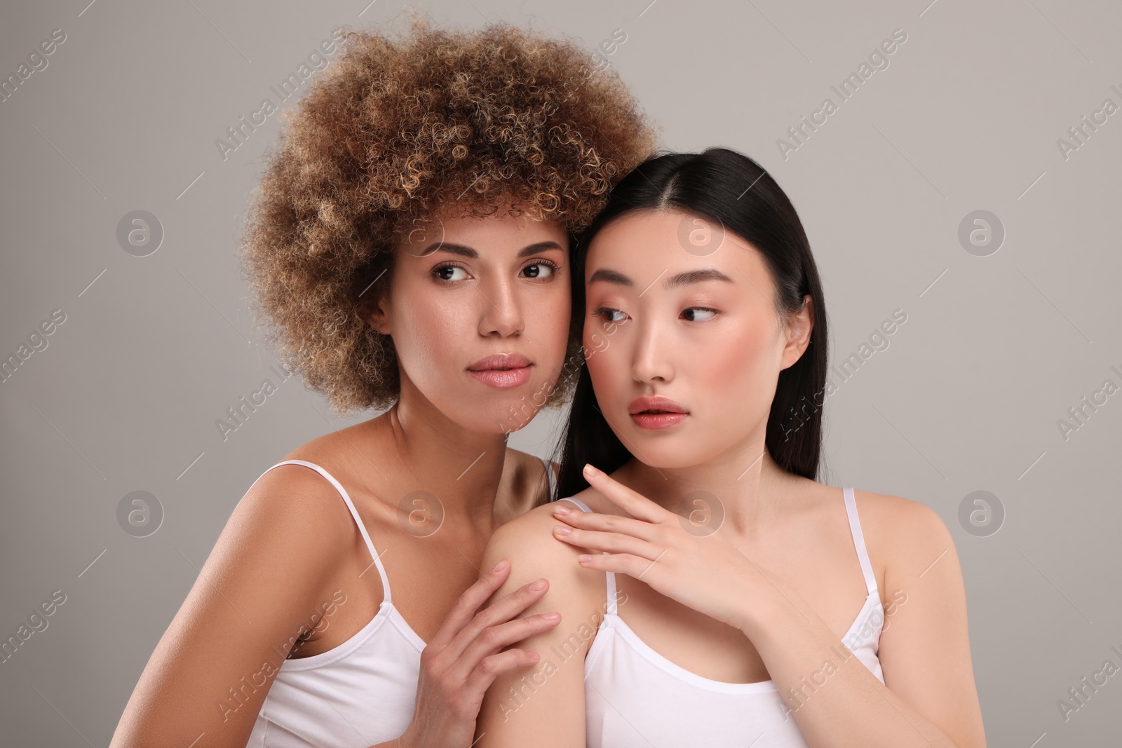 Photo of Beautiful young women with healthy skin on gray background