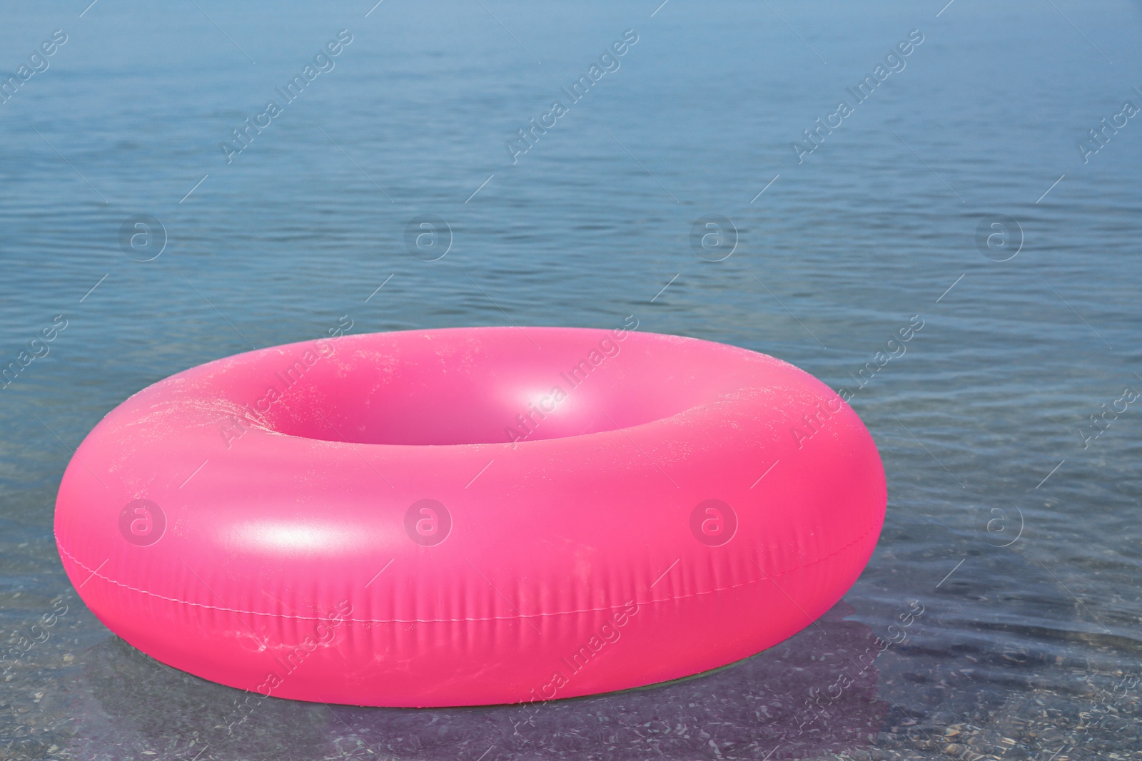 Photo of Bright inflatable ring floating on sea water. Summer vacation