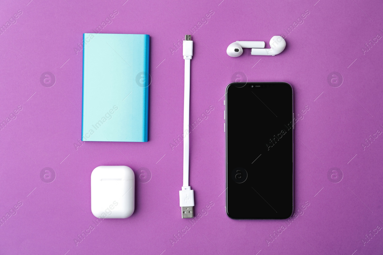 Photo of USB charge cable and gadgets on purple background, flat lay