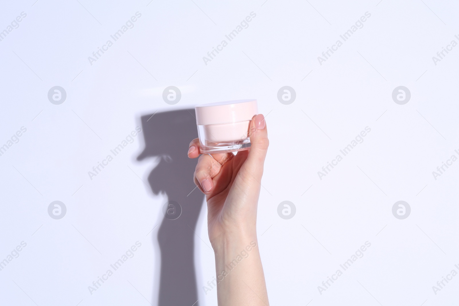 Photo of Woman with jar of cream on white background, closeup