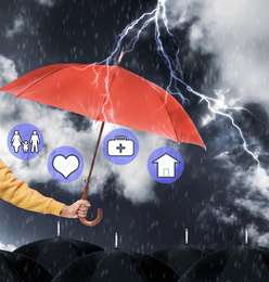 Image of Insurance agent covering illustrations with red umbrella during storm