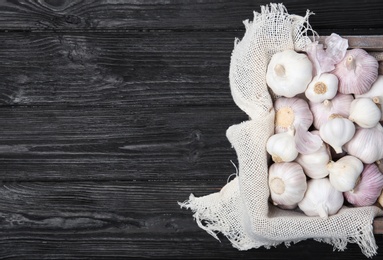 Photo of Crate with fresh garlic bulbs on wooden background, top view