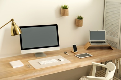 Stylish workplace interior with modern computer on table. Mockup for design