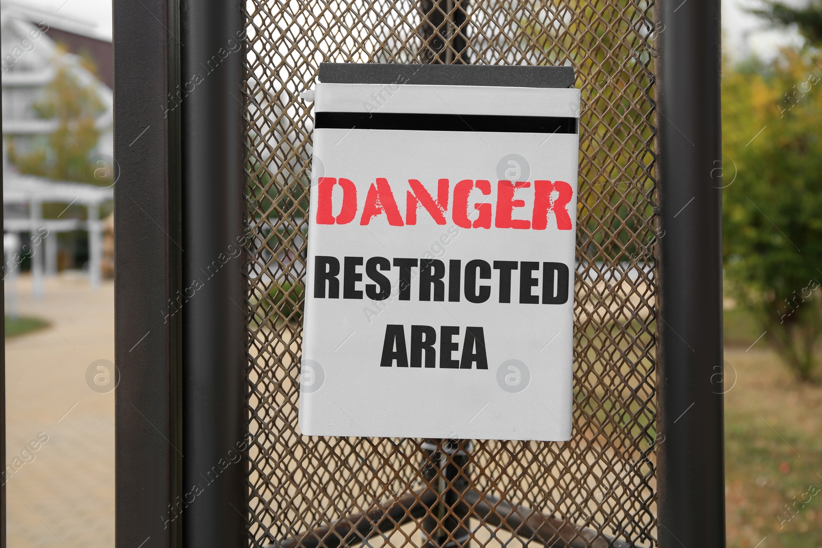 Image of Sign with text Danger Restricted Area on fence outdoors