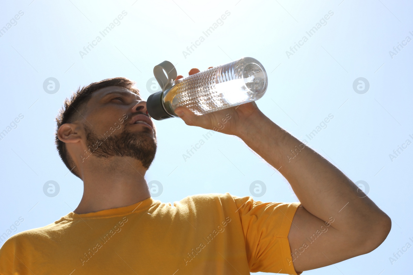 Photo of Man drinking water to prevent heat stroke outdoors