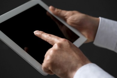 Closeup view of man using new tablet on black background