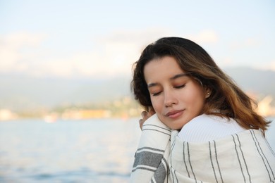 Photo of Portrait of happy young woman near sea. Space for text