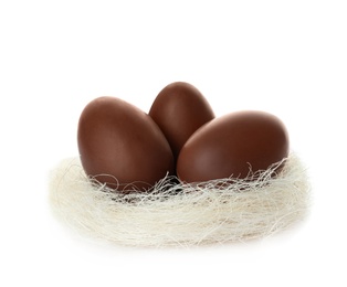 Photo of Chocolate Easter eggs in decorative nest on white background