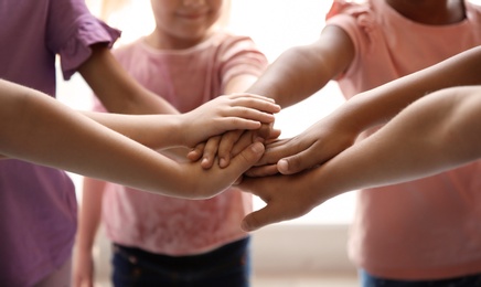 Photo of Little children putting their hands together, closeup. Unity concept