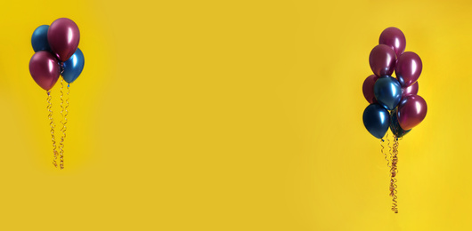 Image of Bright balloons on yellow background, space for text. Banner design 
