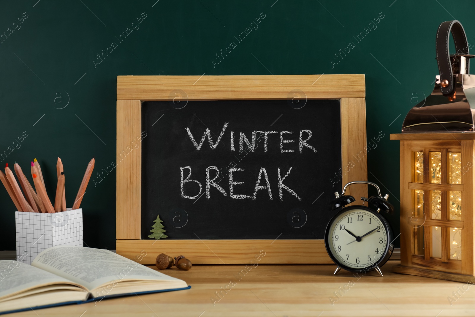 Photo of Chalkboard with text Winter Break, alarm clock and school supplies on wooden table. Holidays concept