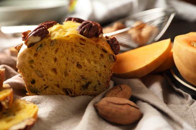 Delicious pumpkin bread with pecan nuts on tablecloth, closeup