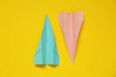 Photo of Different paper planes on yellow background, flat lay