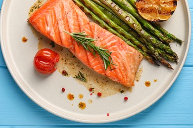Tasty grilled salmon with tomato, asparagus and spices on table, top view