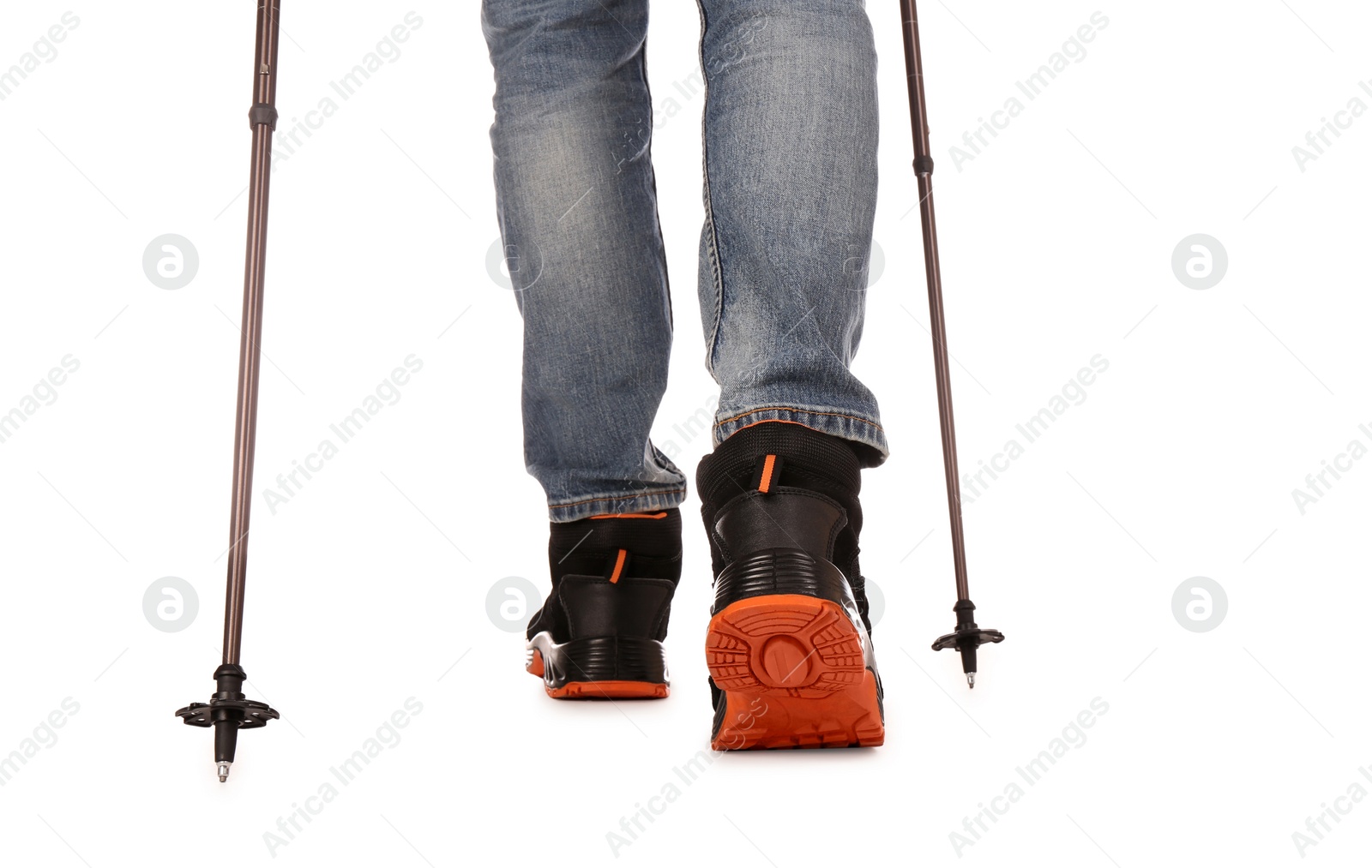 Photo of Man wearing stylish hiking boots with trekking poles on white background, closeup