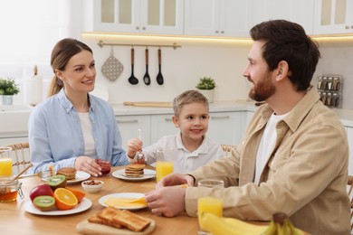 Happy family having breakfast at table in kitchen