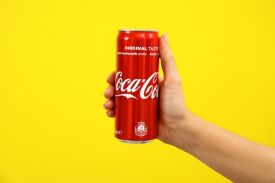 Photo of MYKOLAIV, UKRAINE - NOVEMBER 14, 2018: Woman holding Coca-Cola can on color background