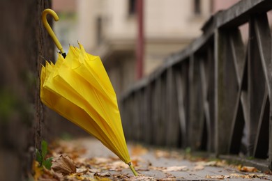 Photo of Autumn atmosphere. One yellow umbrella on city street, space for text